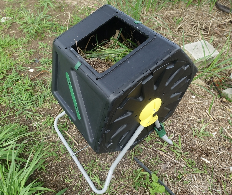 Black tumbler with grass cuttings and compost