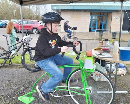Boy cycling on a green smoothie bike