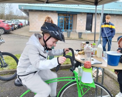 Boy smiling while cycling on green smoothie bike