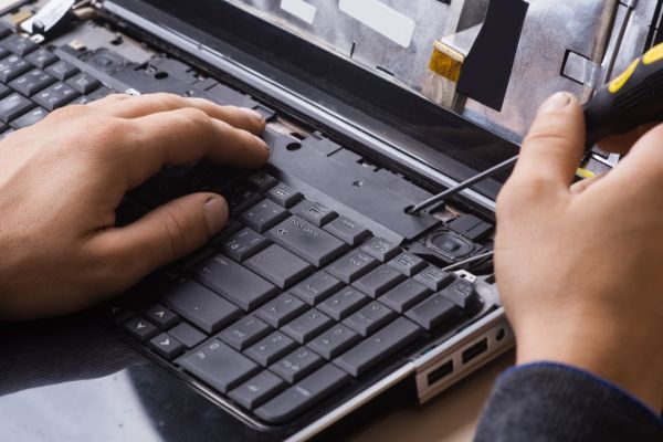 Close up photo of man repairing a laptop